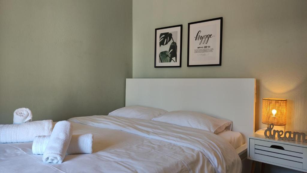 a bedroom with a white bed with towels on it at Hygge Home at Trikala in Tríkala