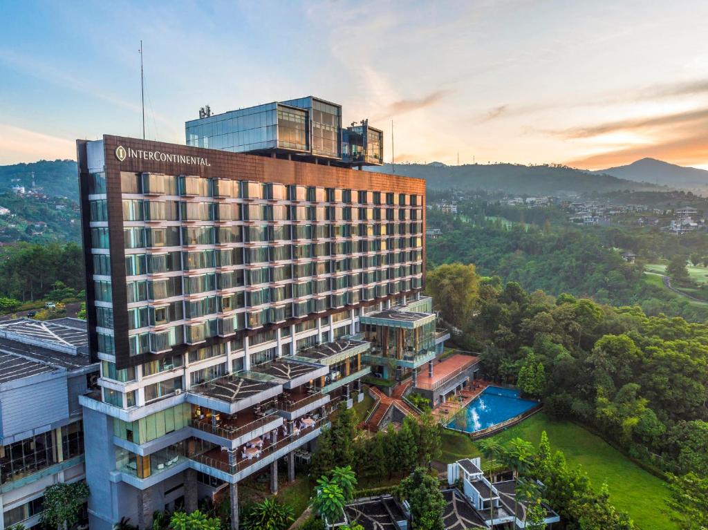 een uitzicht op een gebouw met een zwembad bij InterContinental Bandung Dago Pakar, an IHG Hotel in Bandung