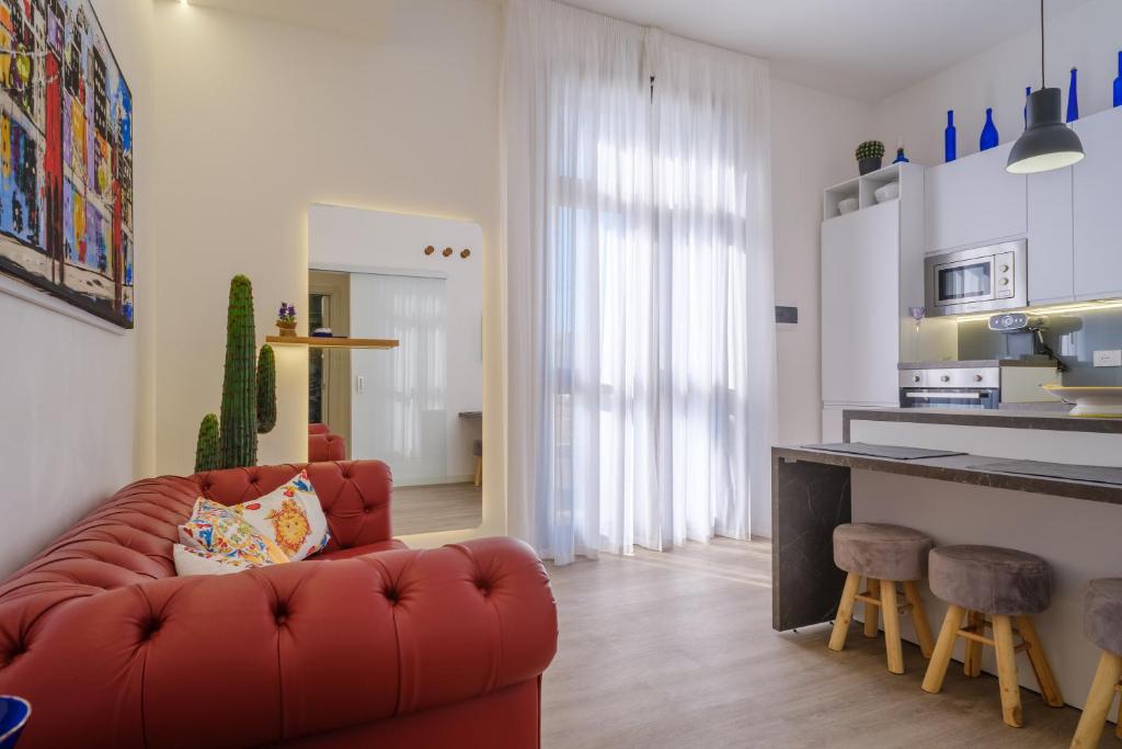 un soggiorno con divano rosso e una cucina di Appartamento Fico D'india a San Cataldo