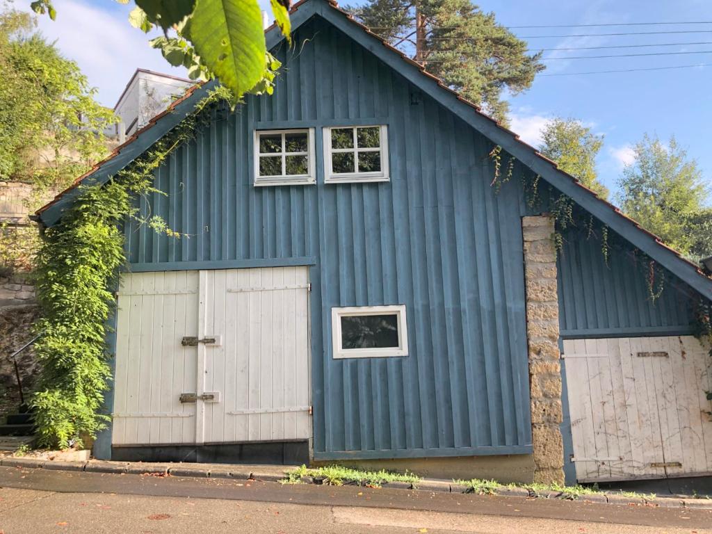 una casa azul con dos puertas de garaje en s'Scheunle - dein Ferienhäusle im Donautal, en Beuron