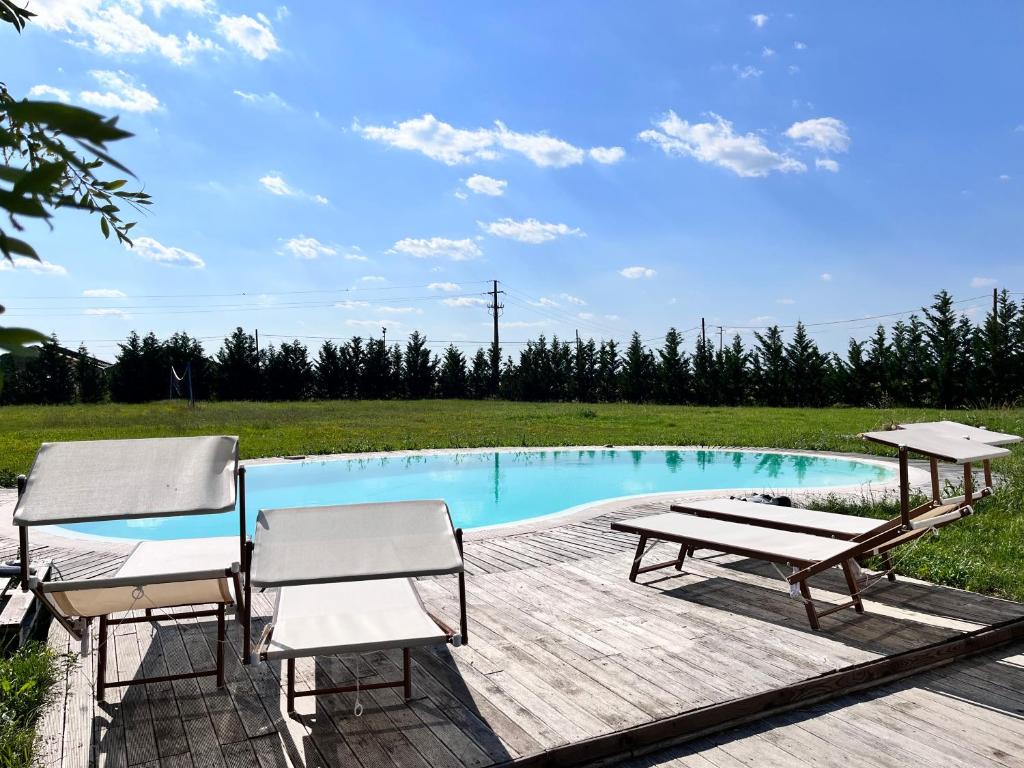 une piscine avec deux chaises et une table dans l'établissement Cottage indipendente con piscina privata, à Masi San Giacomo