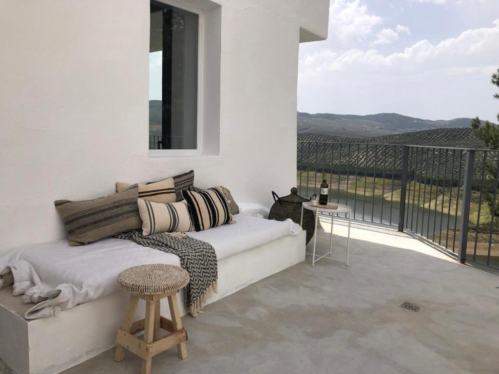 sypialnia z kanapą i balkonem z widokiem w obiekcie Casa Trece w mieście Iznájar