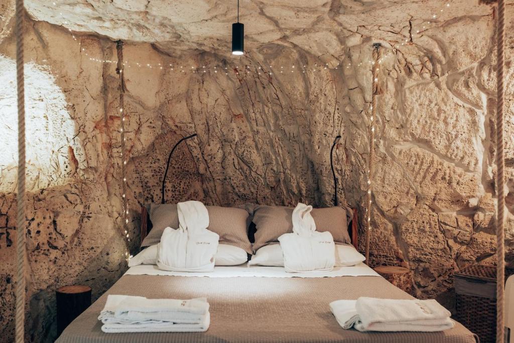 Una cama en una cueva con zapatos blancos. en Grotta Carlotta, en Ostuni