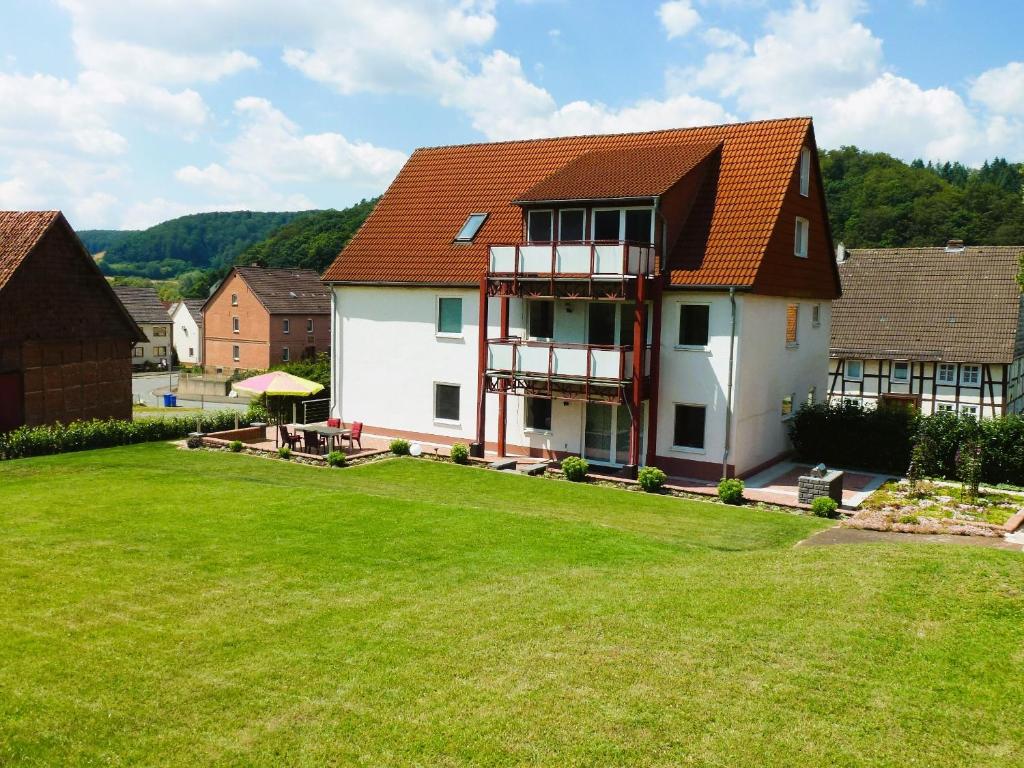 ein Haus mit grünem Rasen davor in der Unterkunft Ferienwohnungen MAXIMA in Bad Arolsen