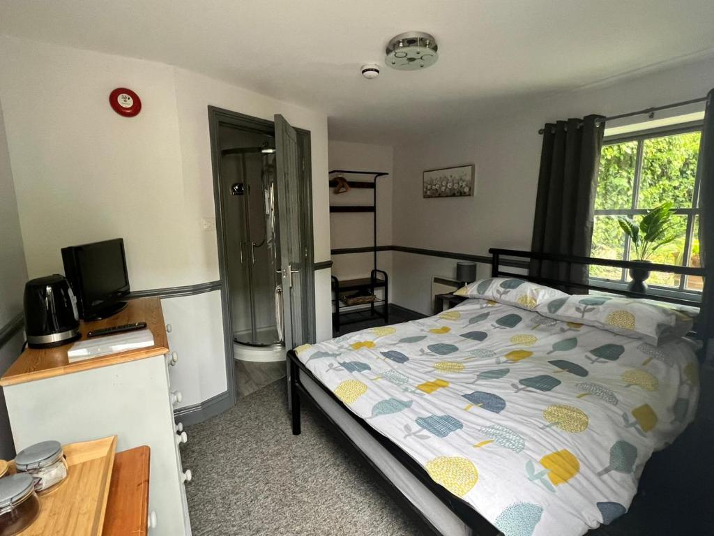 a bedroom with a bed and a desk and a window at The White Hart in Oxford