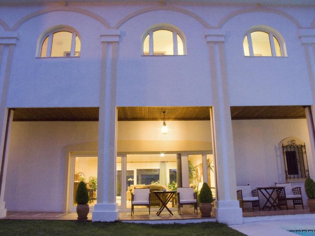 a white house with columns and a table in it at La Luna Blanca in Torremolinos