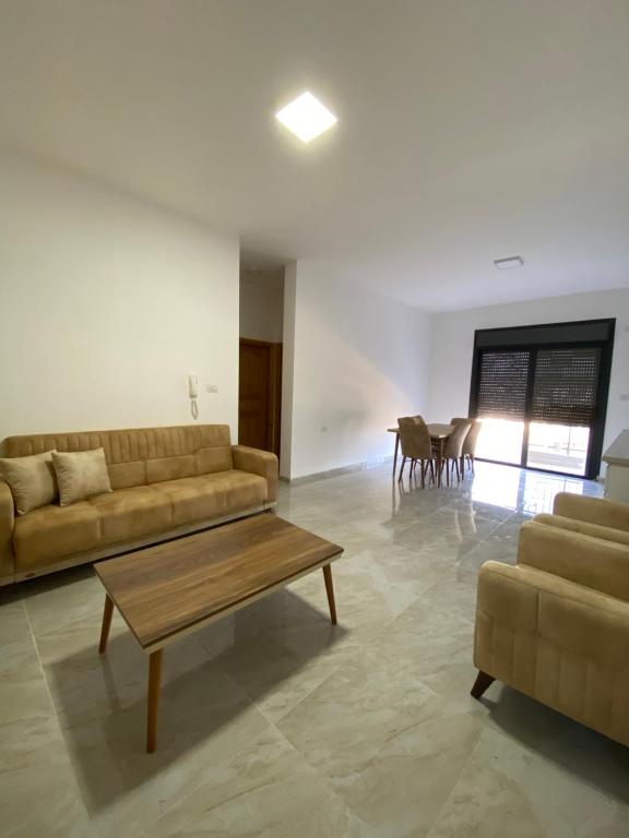 a living room with a couch and a table at Alfred Apartments in Ramallah