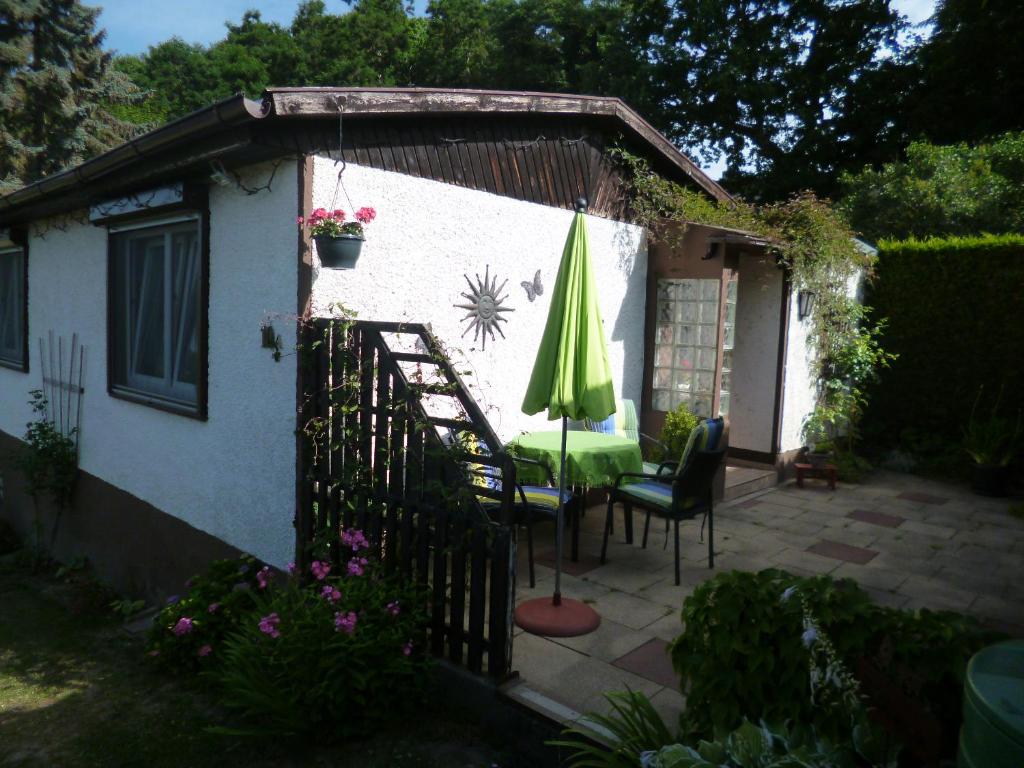 eine Terrasse mit einem Sonnenschirm, einem Tisch und Stühlen in der Unterkunft Ferienhaus ANNE in Thale