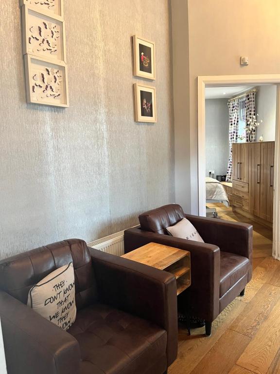 a living room with two leather couches and a table at Stone Lodge B&B in Balrath