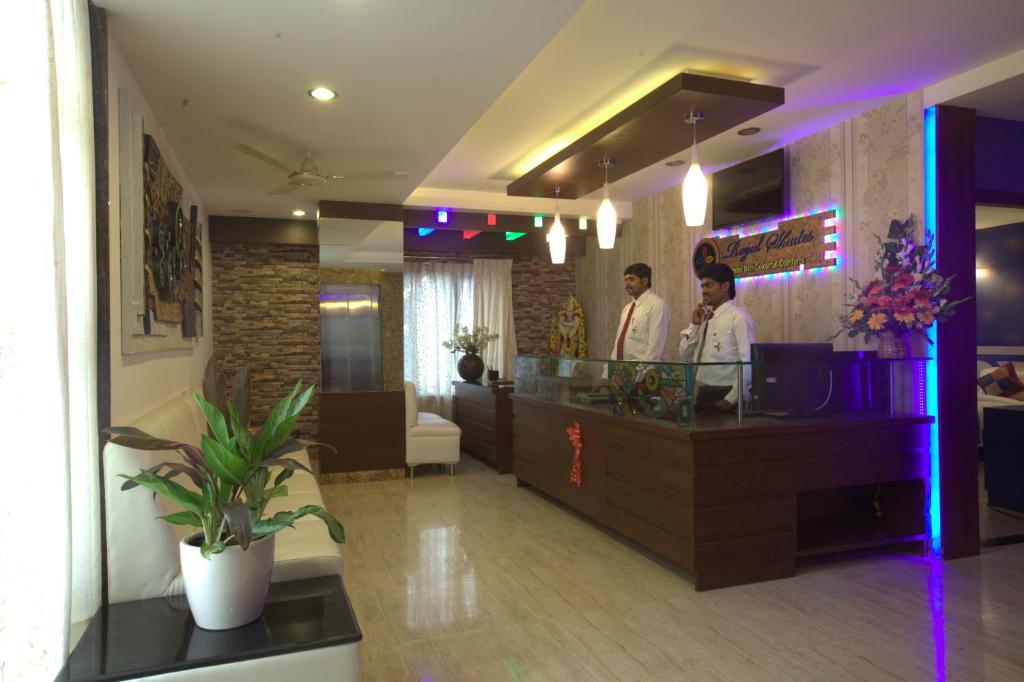 two men standing at a counter in a restaurant at Royal shades kodihali in Bangalore