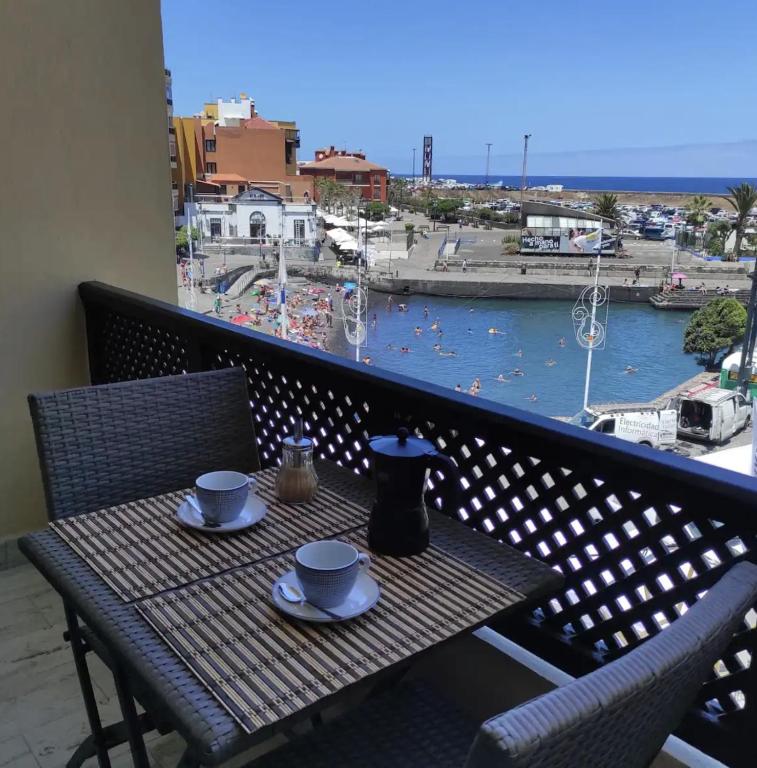 a table on a balcony with a view of a body of water at Cozy Studio Harbour View in Puerto de la Cruz in Puerto de la Cruz