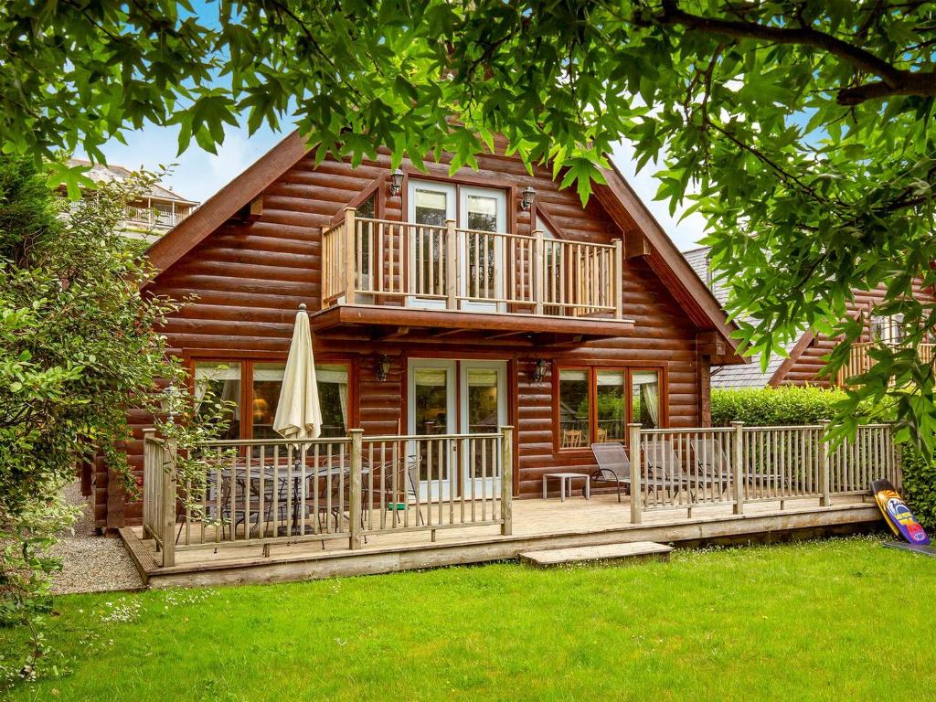 a log cabin with a deck and a patio at Camelog in Little Petherick