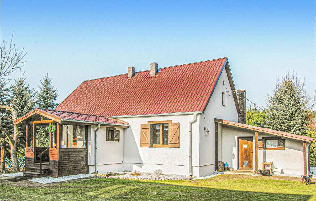 a small white house with an orange roof at Lovely Home In Wronki With Sauna in Chojno
