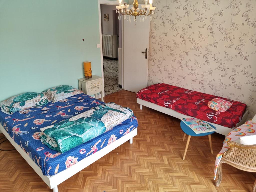 a bedroom with two beds and a couch and a table at Kaly in Audinghen