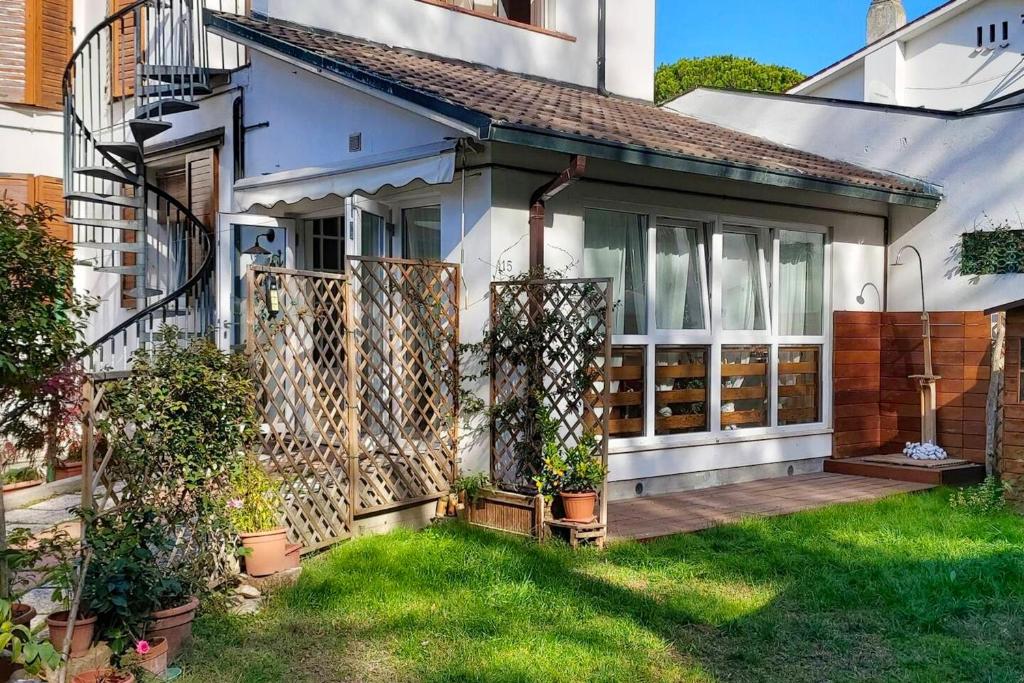 a small house with a wooden porch with plants at One bedroom apartement at Marina di Ravenna 400 m away from the beach with enclosed garden and wifi in Marina di Ravenna