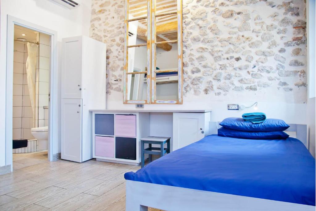 a bedroom with a blue bed and a bathroom at Oasis in Antibes