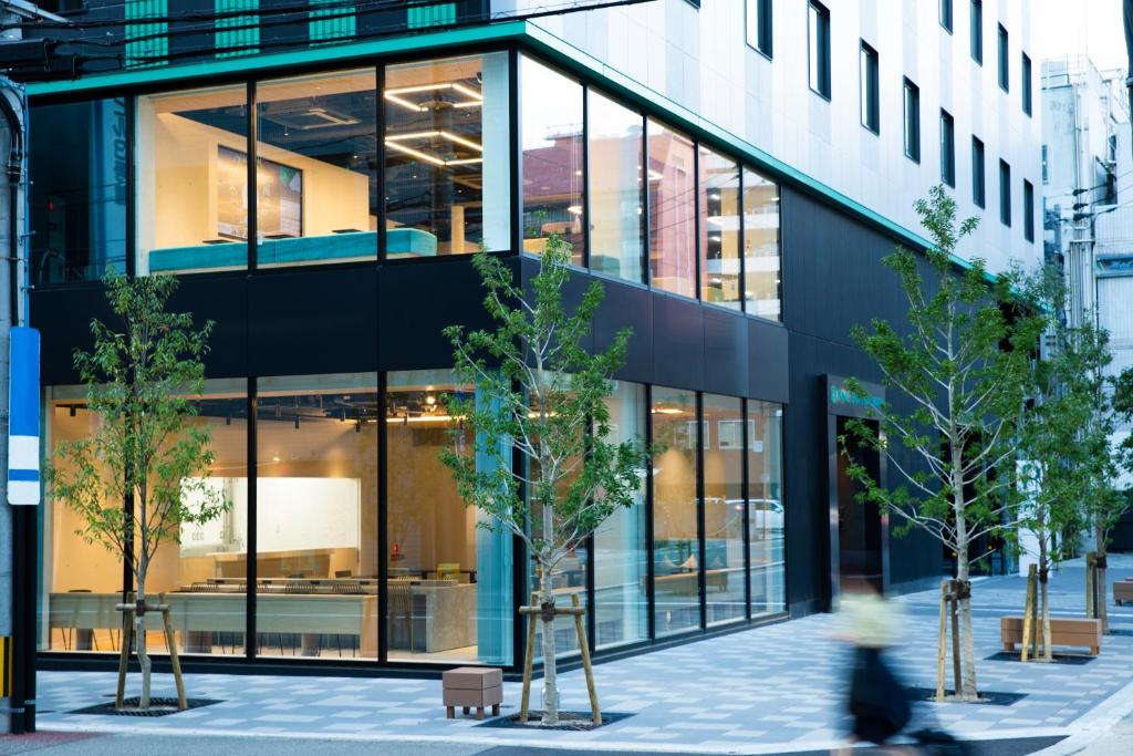 Prince Smart Inn Hakata في فوكوكا: يمر شخص بجوار مبنى به نوافذ كبيرة