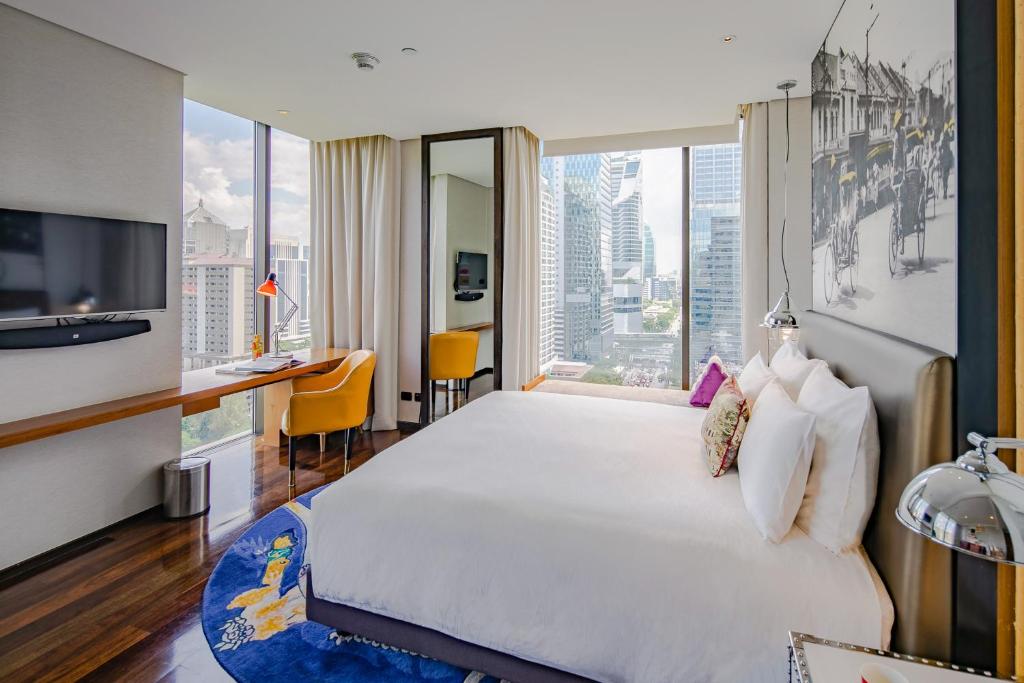 ein Hotelzimmer mit einem großen Bett und einem großen Fenster in der Unterkunft Hotel Indigo Bangkok Wireless Road, an IHG Hotel in Bangkok