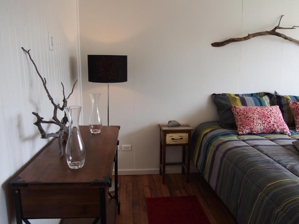 uma sala de estar com um sofá e uma mesa com vasos em Wild Hostel em Puerto Natales
