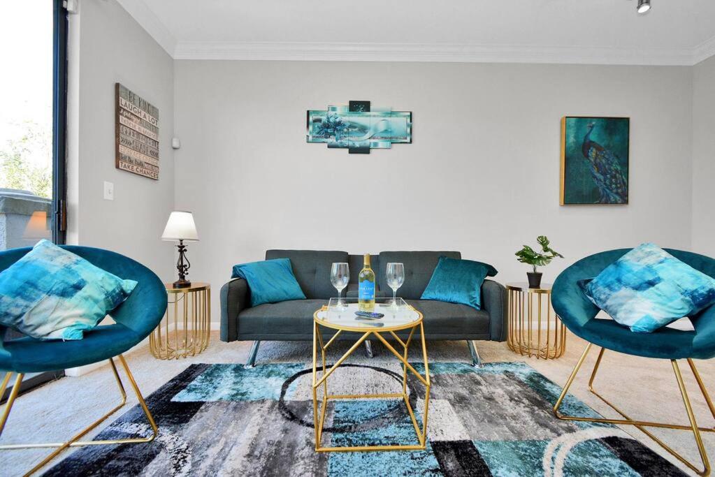 a living room with a couch and two chairs and a table at The Turquoise Suite in Houston