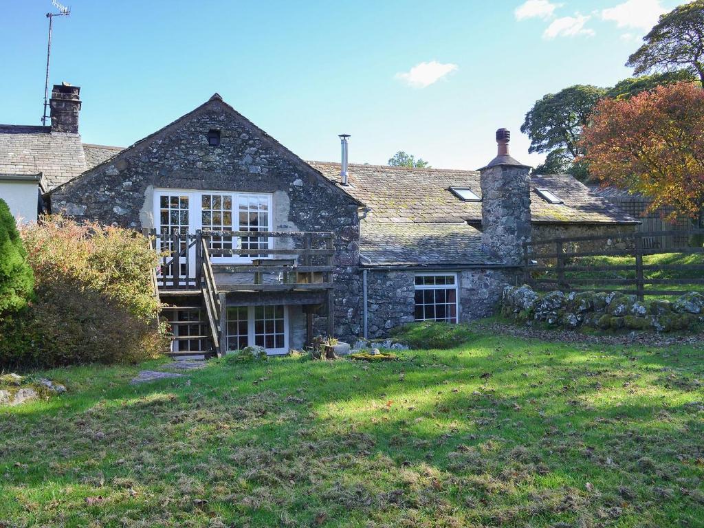 an old stone house with a deck in the yard at Birkerthwaite Cottage-w41479 in Eskdale