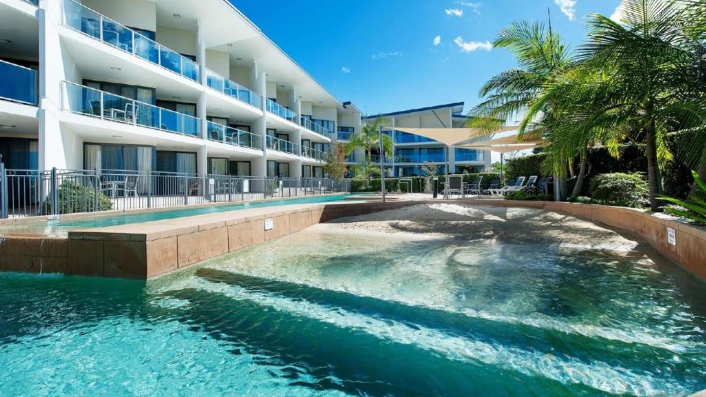 a swimming pool in front of a building at 108 The Boathouse in Tea Gardens