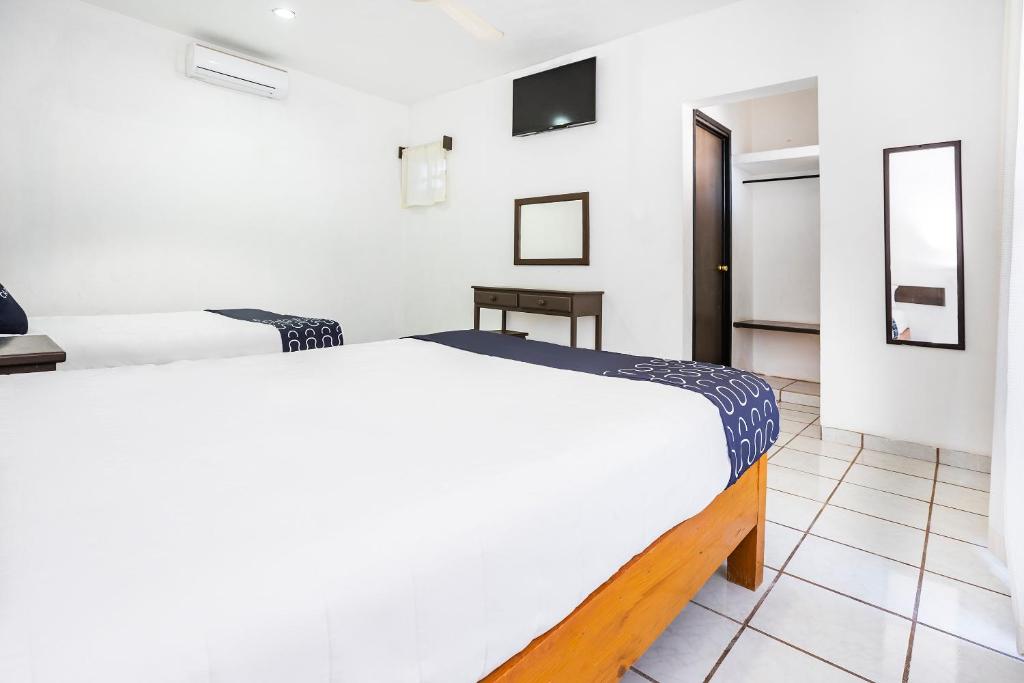 Postel nebo postele na pokoji v ubytování Capital O Oxtankah,chetumal bay