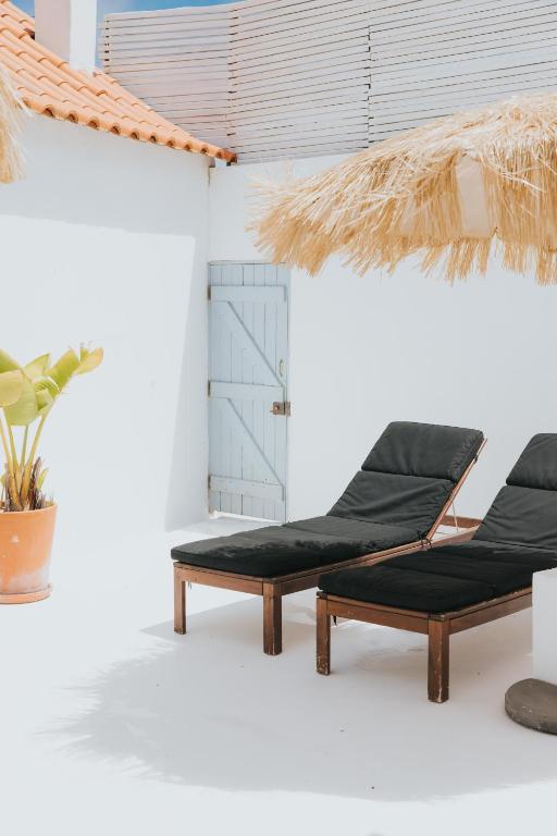 two beds in a room with a potted plant at Senhora do Cabo Meco Homy Holidays in Sesimbra