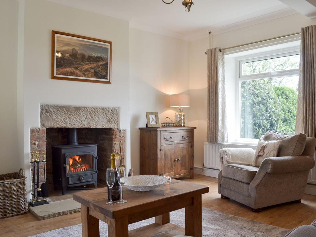 - un salon avec une cheminée et une chaise dans l'établissement Ling Farm Cottage, à Holmewood