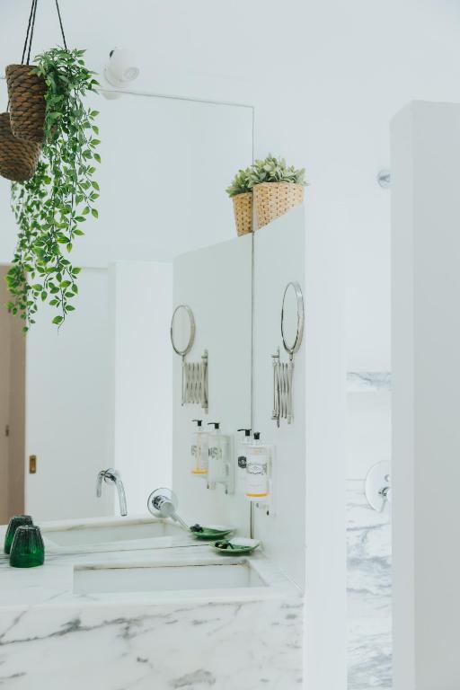 a bathroom with white marble countertops and plants at Senhora do Cabo Meco Homy Holidays in Sesimbra
