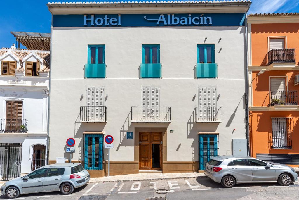 een hotel met twee auto's die er voor geparkeerd staan bij Hotel Albaicín - Auto Check-in in Coín