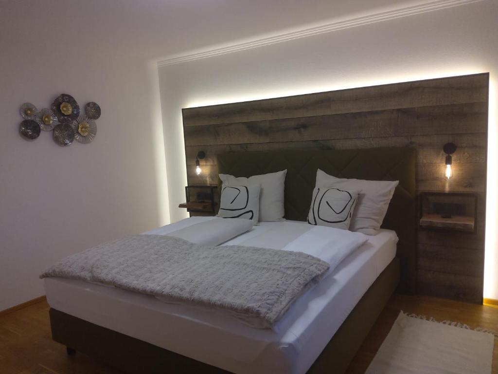 1 dormitorio con 1 cama grande con 2 caras en las almohadas en Ferienwohnungen Kienesberger, en Tiefgraben