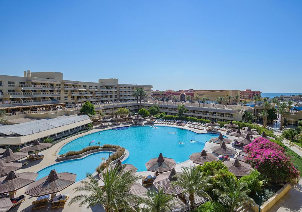 a large swimming pool with umbrellas and a resort at Sindbad Club in Hurghada