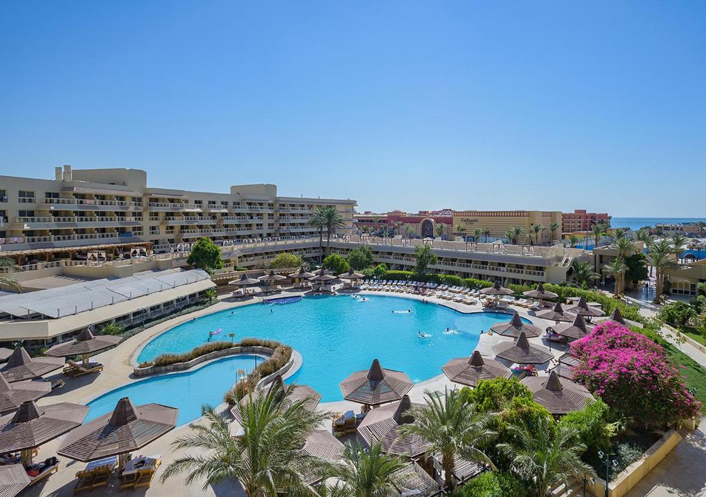 een groot zwembad met parasols en een resort bij Sindbad Club in Hurghada