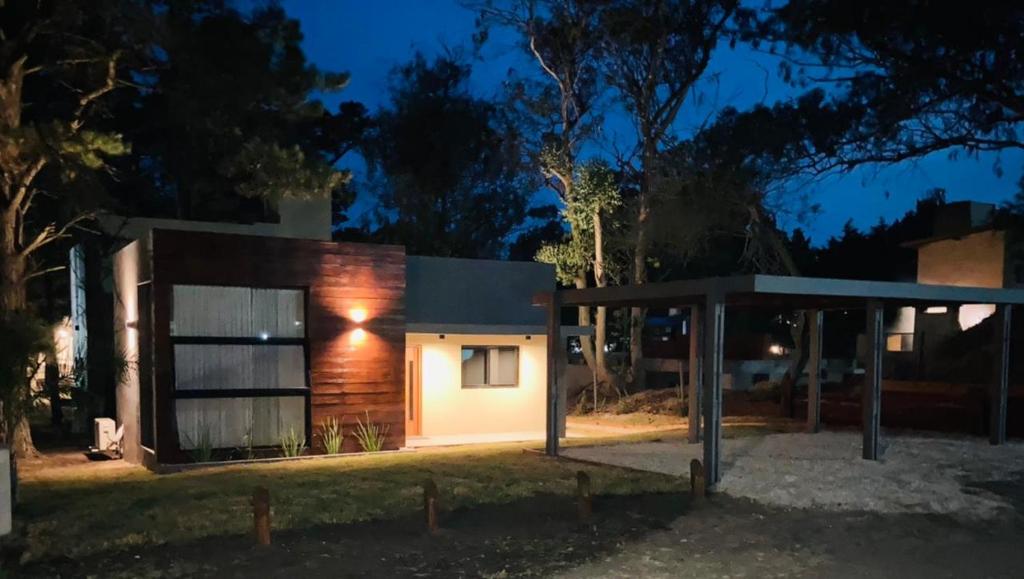 una casa illuminata di notte con un padiglione di Pura Vida 1 a Mar de las Pampas
