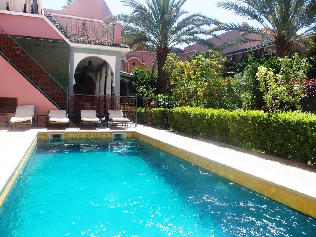 a swimming pool in front of a pink house at Riad Dar Hajra in Taroudant