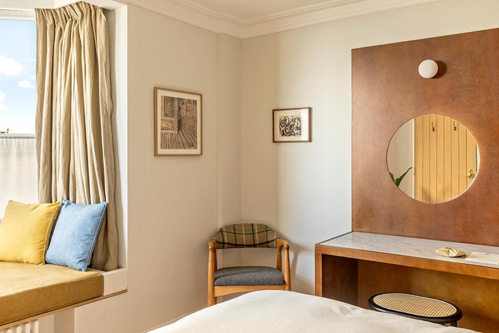 a bedroom with a bed and a mirror and a chair at Fort Road Hotel in Margate