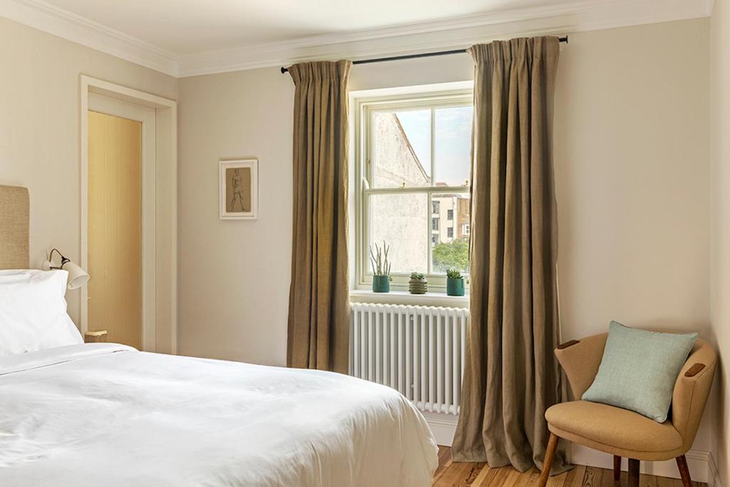a bedroom with a bed and a window and a chair at Fort Road Hotel in Margate
