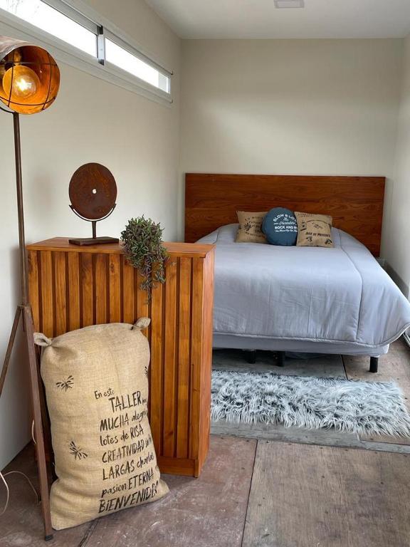 1 dormitorio con 1 cama con cabecero de madera en Costa de Anzorena en Tunuyán
