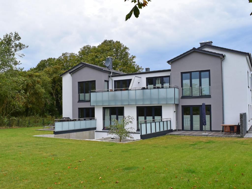 a large white house with a large yard at Exclusives Appartement auf Fehmarn in Petersdorf auf Fehmarn