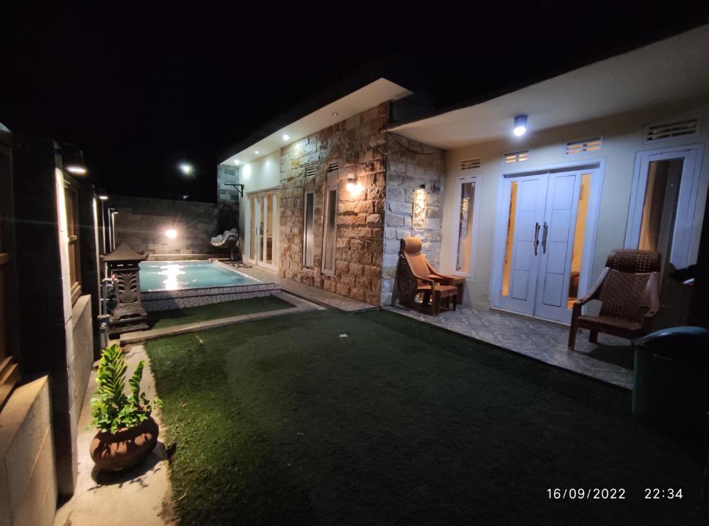 einen Hinterhof in der Nacht mit Pool in der Unterkunft Puncak Pinus and Pool in Batu