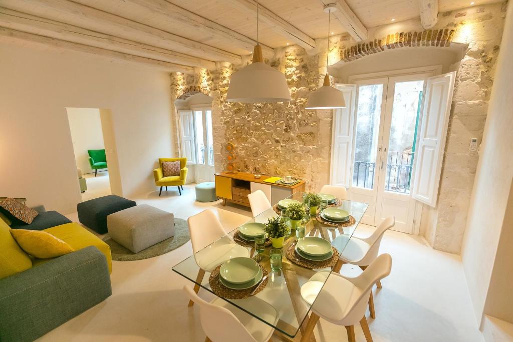 salon ze szklanym stołem i krzesłami w obiekcie Veronique by Dimore in Sicily w Syrakuzach