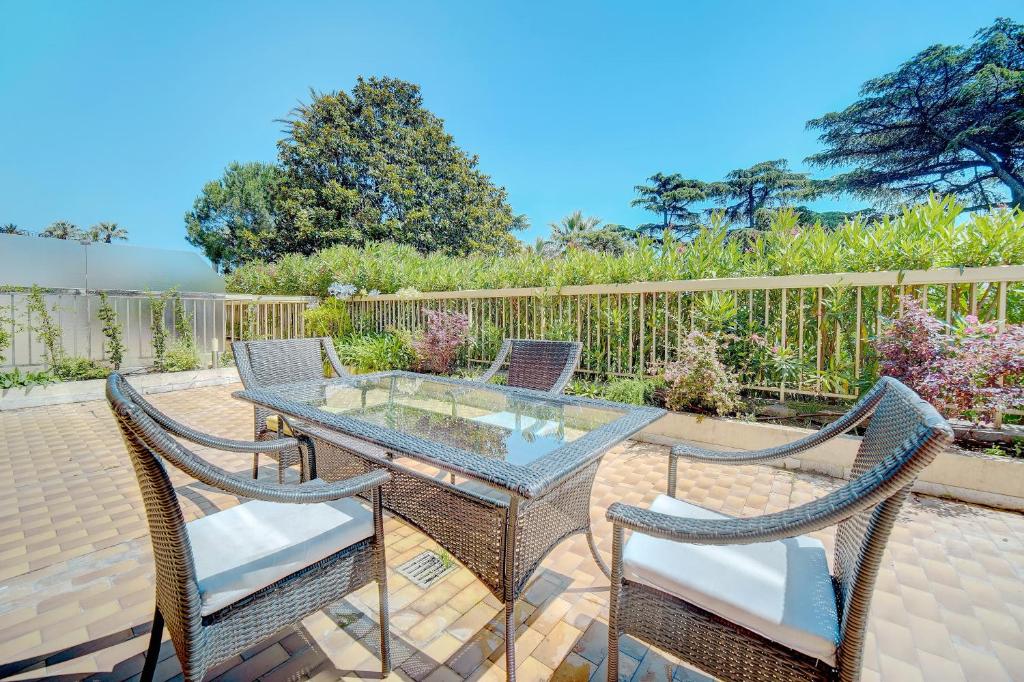 d'une terrasse avec une table en verre et deux chaises. dans l'établissement comfortable 3 bedroom, superb south terrace, à Cannes