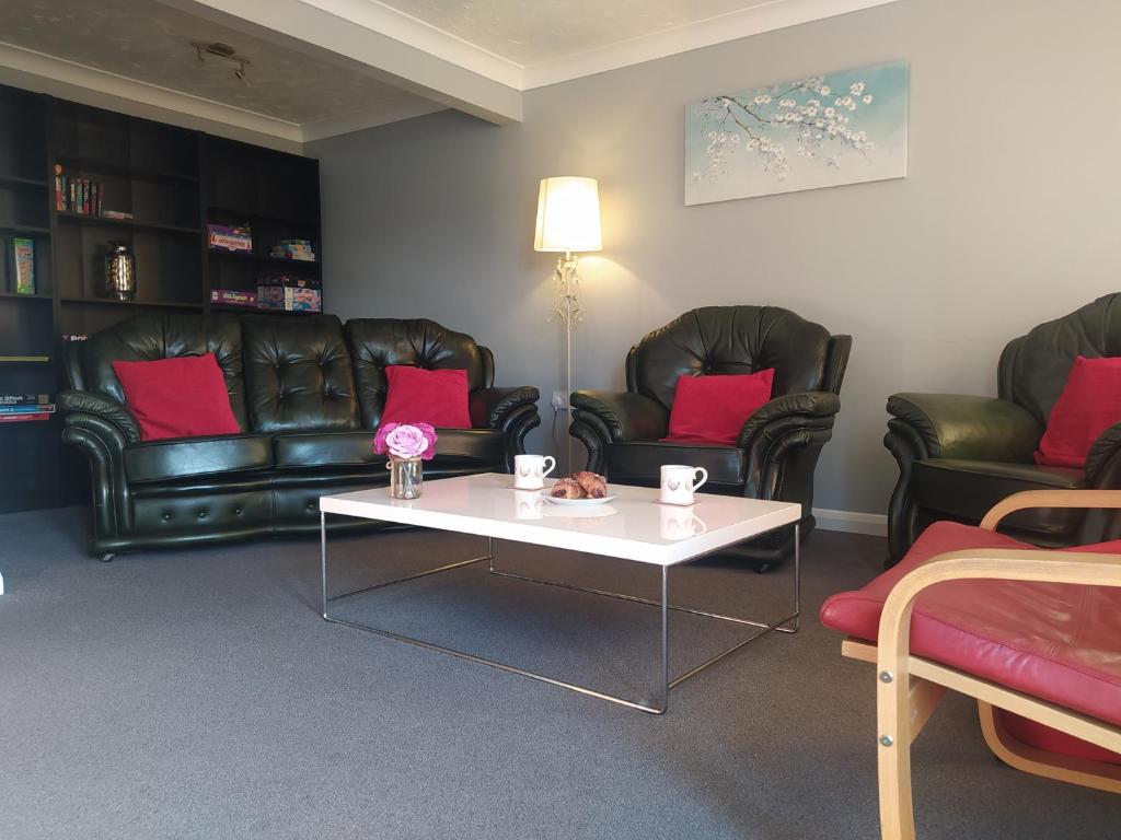 a living room with leather couches and a coffee table at Rutland View in Oakham