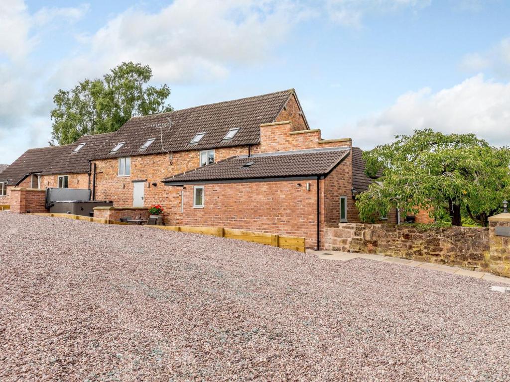 an external view of a brick house with a gravel driveway at Tadpole Cottage At Frog Hall in Tilston