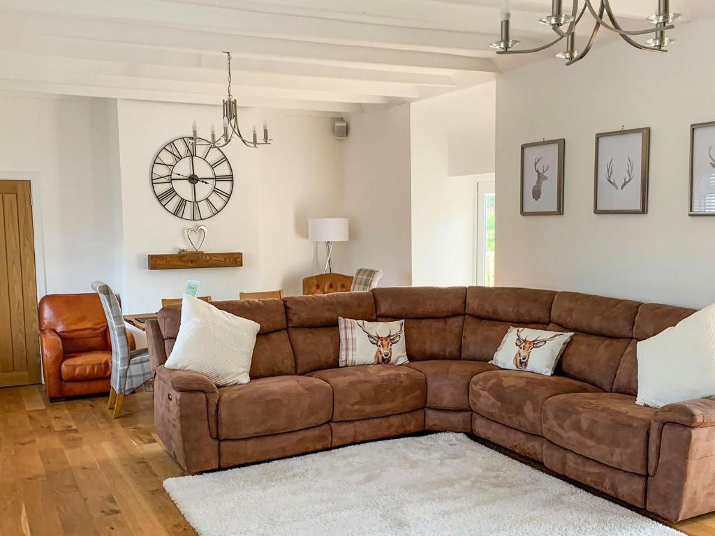 a living room with a brown couch in a room at Holmbyre Smithy in Dalry
