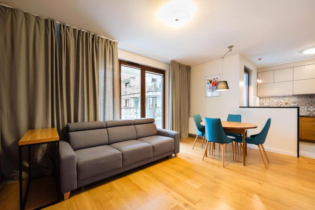 a living room with a couch and a table at Sokratesa Estate Ideal Apartment in Warsaw