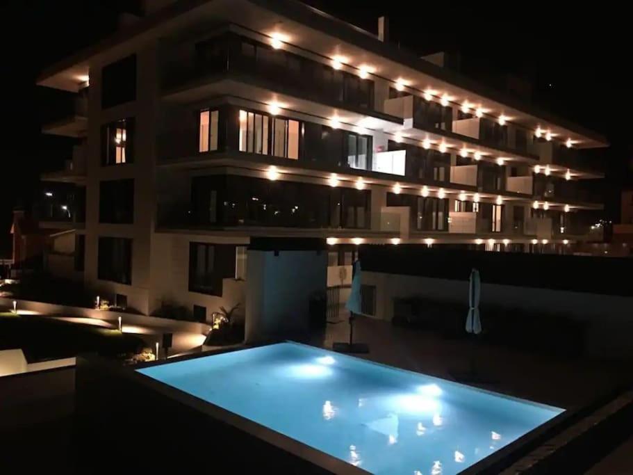 a building with a swimming pool at night at Precioso apartamento con terraza y piscina en Portonovo-Sanxenxo in Portonovo
