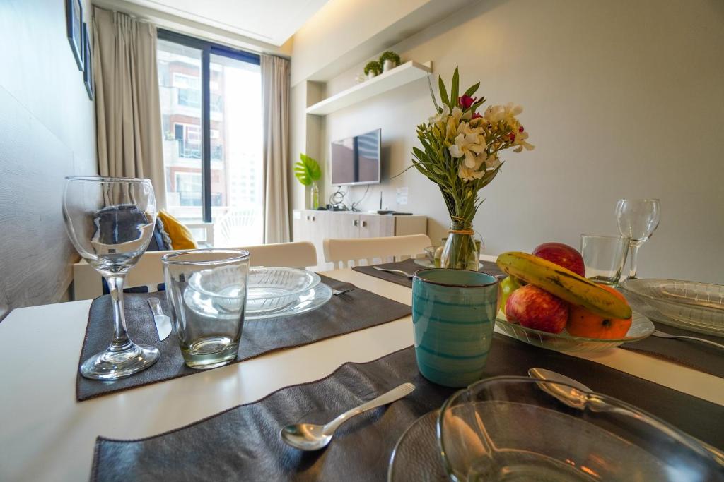 a kitchen with a table with a bowl of fruit and glasses at Rent for Days IV- Norte Vip in San Miguel de Tucumán