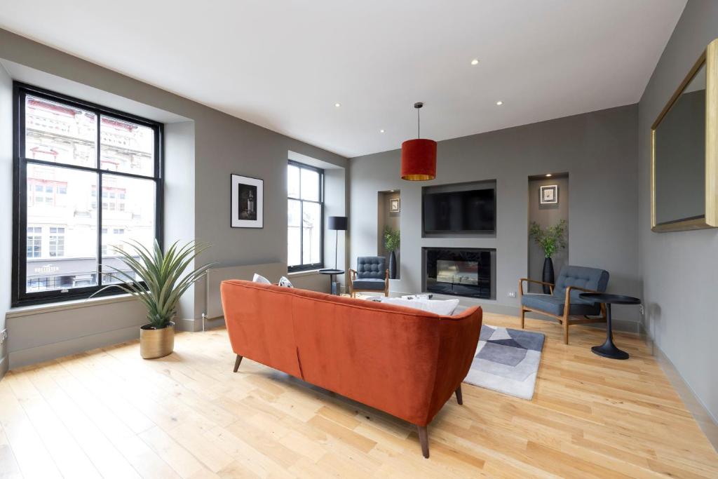 a living room with a couch in the middle at ALTIDO Stylish 2-bed flat in New Town in Edinburgh